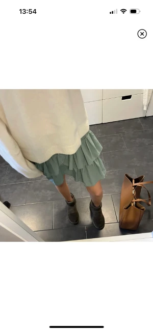 Volangkjol - Volangkjol i strl m som säljes då den tyvärr inte passar mig. Väldigt bra skick och snygg militärgrön färg. Midjan är väldigt stretchig och lite större