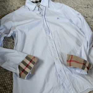 Burberry skjorta - Ljusblå burberry skjorta storlek:M Skick 9/10 Kom till dm vid minsta intresse!