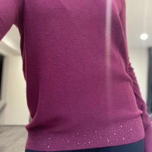 stickad tröja med stenar🌟 - Vinröd (ser ljusare ut i starkt ljus) stickad tröja med fina glitterstenar nedintill. Några stenar saknas, men det är inget man lägger märke till. Hör av er för fler bilder eller funderingar💖
