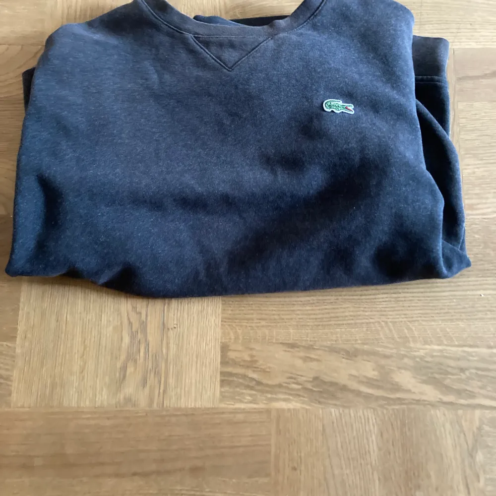 Fin Lacoste tröja i strlk M men passar även S fint skick färg mörkgrå. Hoodies.