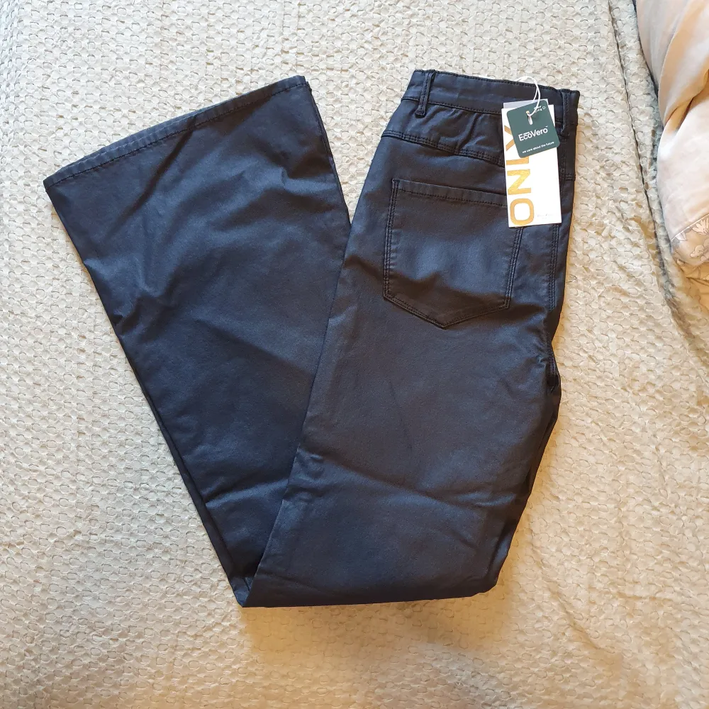 Coola utsvängda jeans. Svarta med en lätt läderish finish på dem. Oanvända och lapparna sitter fortfarande kvar  Storlek: M/30. Jeans & Byxor.
