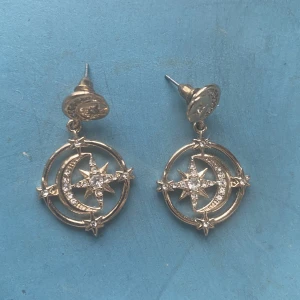 Örhängen  - Fina och trendiga guldfärgade örhängen med måne och stjärnor. 