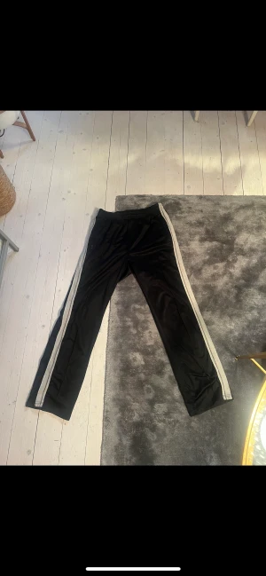 Our legacy byxor - Trackpants från Our Legacy. Storlek 48. Saknar snöret runt midjan (kan fixas med nytt snöre) och en del på ena dragkedjan är av.