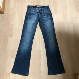 Jeans, Only - Ett par lågmidjade och utsvängda jeans ifrån Only i använt skick! Står att de är 32/34” men har krympt ganska mycket, midjan är cirka 67 cm. Jag har lagat de eftersom det var stora hål vid slutet på benen. Mönstret på ena fickan är borta(se bild 3).
