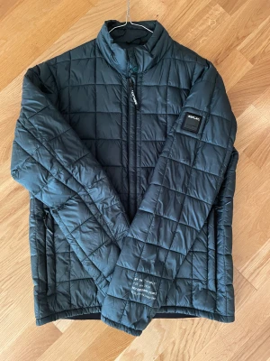Replay jacka  - Lätt o följsam jacka  från Replay i en smakfullt mörk grön färg. Herrmodell Regular fit storlek M  Känns som dunfyllning men är Polyester  utsida Polyamid.  Pris 500kr
