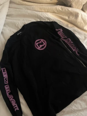 Svart långärmad rosa detaljer  - En svart lite tjockare långärmad med rosa tryck på från new black 