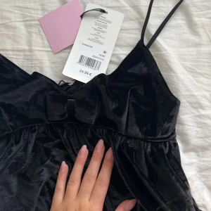 Sametes topp med rosett - Söt topp i sammet med rosett fram, tyvärr för liten för mig i bysten. Storlek M, aldrig använd.