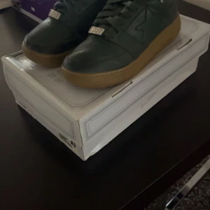 Bape sta low - Bape sta low m1 green orchard! Storlek 44/43 Skorna är väl använda och i ok skick.  Färgen fram på skon har börjat släppa, tyget i hälen är lite trasigt. Förutom det är det ett par schyssta beaters. box och kvitto medföljer bud mottages Mer bilder i PM!  
