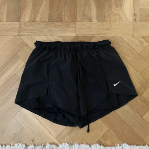 NIKE shorts 2-in-1 - Shorts från Nike, använda fåtal ggr. Har inbyggda cykelbyxor. Ena kanten av dem har släppt lite sömmen men inget man tänker på då det täcks av shortsen ytterdel. Stl S 