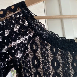 Overall - Svart overall med spets och fickor.