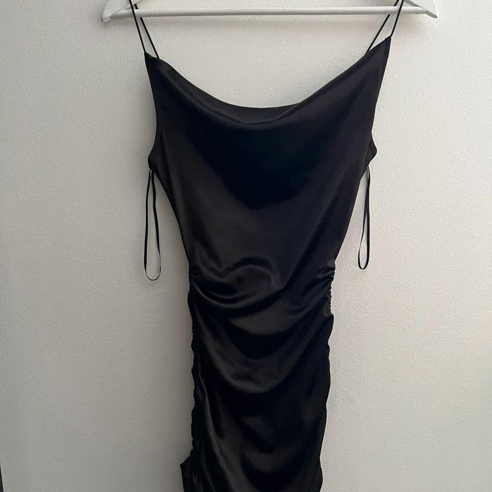 En svart satin klänning använd 1-3 gånger och är i bra skick och är ett fint och stretchigt matrial. Klänningar.