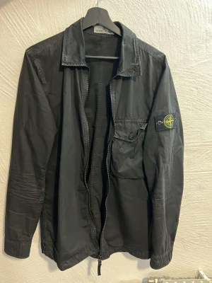 Stone island overshirt - Säljer nu min stone island overshirt i storlek M. Den är i väldigt bra skick inga skador etc. Kan mötas eller frakta den.