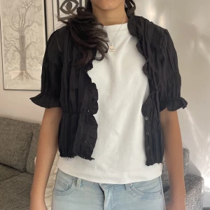 Svart top/bolero - Svart topp eller bolero från Zara. Jättefin med t-shirt under eller bara knäppt. 