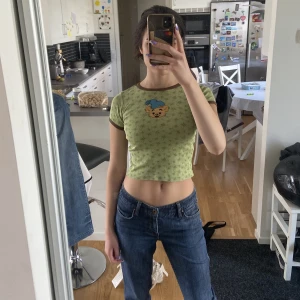 baby tee  - en grön baby tee med bamse tryck! jättesöt:) säljer då jag rensar garderoben. begagnat men bra skick, är köpt secondhand. Köpare står för frakt 💓 kolla gärna min profil för liknande;) OBS, lite tighta i armarna så max strlk s användare!!