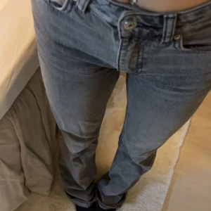 Mid waist grå jeans  - Mid waist grå jeans från Gina tricot. Fina skick förutom ett litet hål längst nere på det högre benet, syns dock itne mycket. Jag är 165 och dom är långa på mig💕