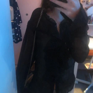 Svart blus - Jätte fin Stockholmsstil blus med volanger,ganska genomskinlig dock. Aldrig använt den💕