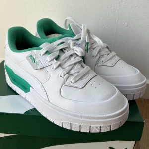 Puma sneakers - Vita/gröna sneakers från Puma. Storlek 38.5. Aldrig använda utan endast provade inomhus, jättebra skick! Säljes då jag aldrig har använt dom. 