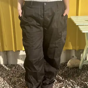 Svarta cargo pants som jag tror är från boohoo. Det går att dra in i midjan (sista bilden) så den går att ha från 110cm till ca 99cm i midjan. De går även att dra åt vid anklarna om man inte vill ha dom raka. Jag är 165 cm och dom är ganska långa på mig