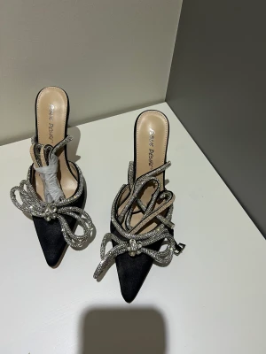 Svarta klackar  - Jätte fina svarta klackar med ett band som går att rulla runt benet. Helt oanvända med plaster kvar 