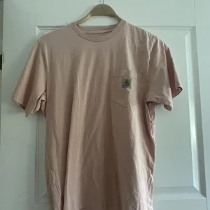 Rosa/beige carhartt t-shirt strl M - Rosa/beige ish t-shirt från carhartt i storlek M. Knappt använd så den är i nyskick.