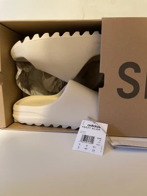 Yeezy slide Bone 2022 - Adidas Yeezy Slide Bone (2022)  SKU: FZ5897  [👟] Size: EU 44.5 / US 10 / UK 10  [💵] pris: 2099kr  [📶] skick: 10/10 oanvänd  
