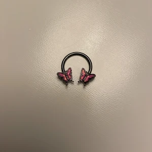 Septum piercing  - Bra skick med gulliga fjärilar.