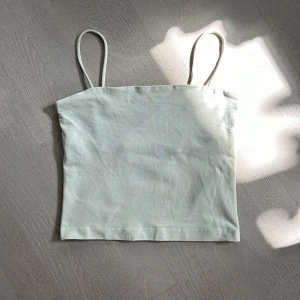 Croppat linne - Ett mintgrönt croppat linne från Gina Tricot i S. Dubbelt tyg över bysten. 
