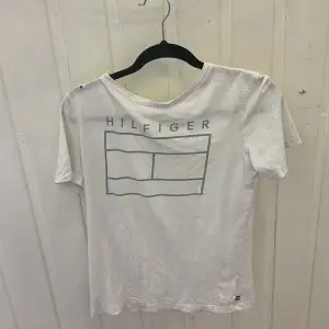 En Tommy Hilfiger t-shirt i storlek 176. Den är välanvänd och har några småhål i sig. 