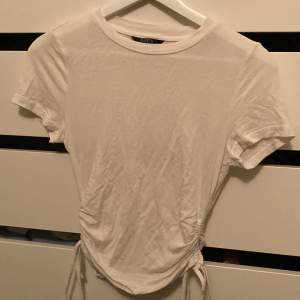 Gullig basic T-shirt med snören på sidan för att justera längd, inget tecken på användning