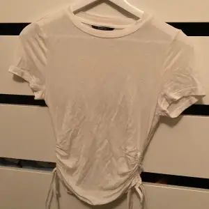 Gullig basic T-shirt med snören på sidan för att justera längd, inget tecken på användning