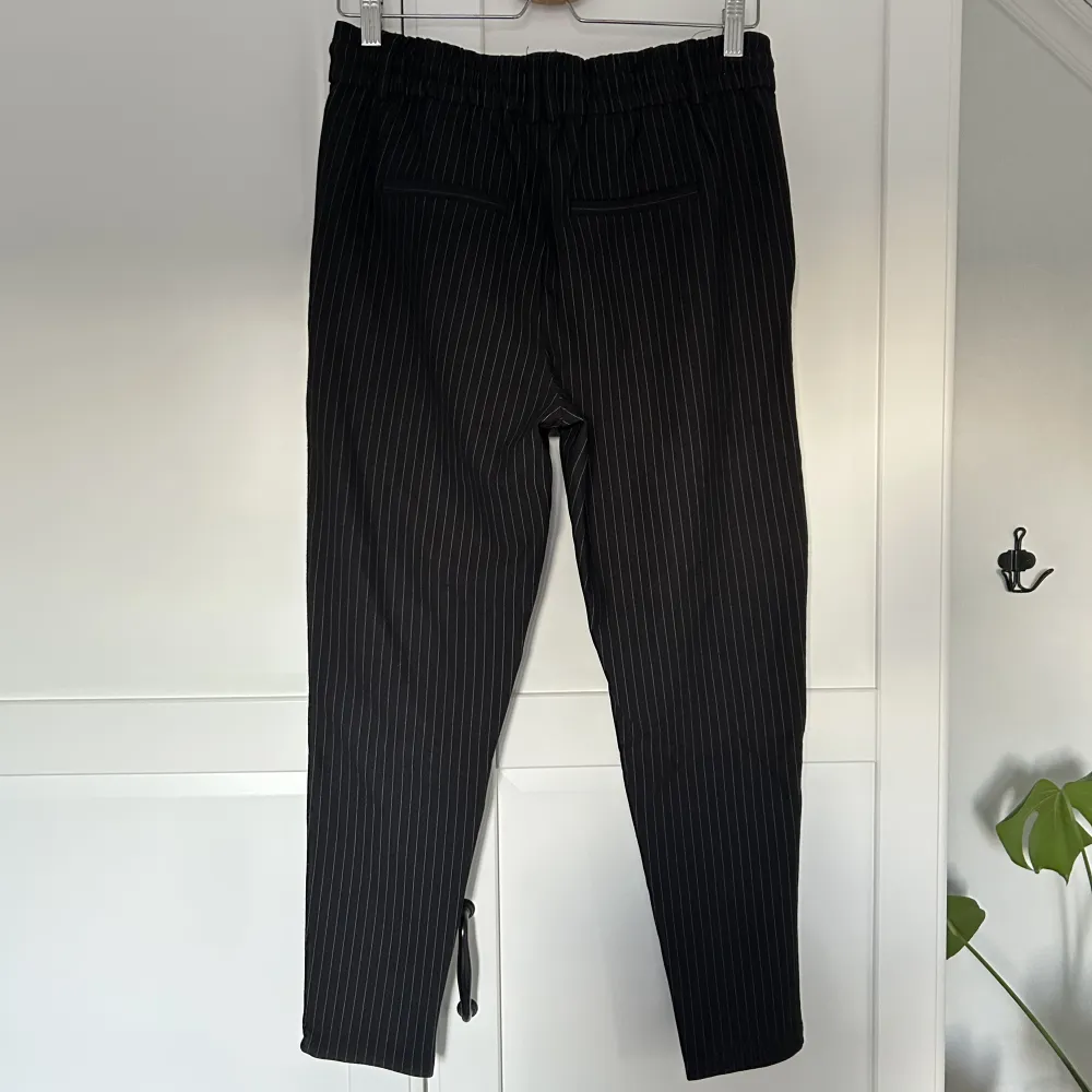 Svarta kostymbyxor med vita ränder från Only. Stretchigt material. . Jeans & Byxor.