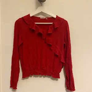 Röd tröja med volanger och andra detaljer. Mycket fin topp.