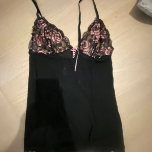 Fint spetslinne - Tunt svart linne med spets upptill och rosa blommor, helt oanvänt!