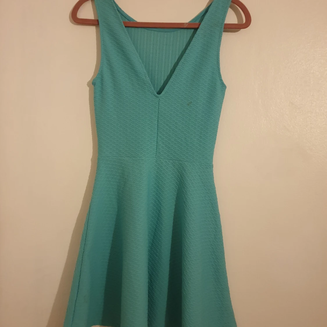 Turkos miniklänning med strukturvävt tyg och öppen rygg. - 90