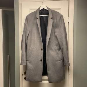 Grå kappa från HM - Grå kappa i från HM i storlek 50. Två innerfickor och i väldigt bra skick.