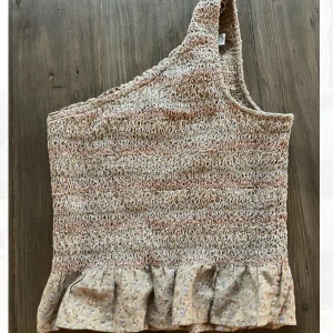 Trendig Asymmetrisk topp - Säljer min jättesöta american eagle topp som är perfekt nu till sommaren!❤️❣️ Har endast använd 2-3 gånger och den är i storlek XS💞 Dma för fler bilder eller frågor!✨✨