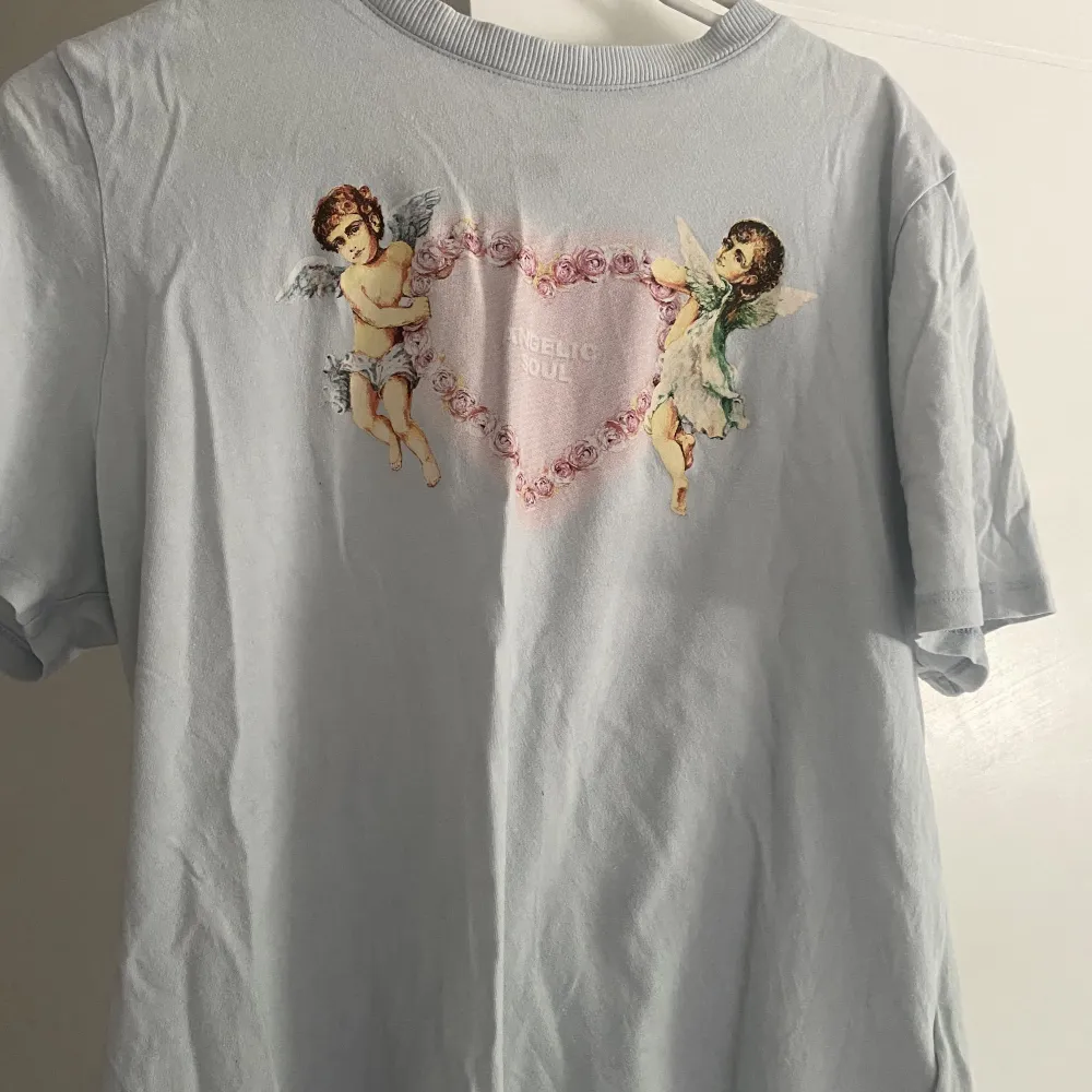 en gullig pastellblå t-shirt med två änglar. inte använt den så mycket, därför säljer jag den!. T-shirts.