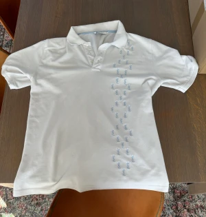 Vit Ysl Pikétröja  - Exklusiv piké från Yves Saint Laurent. Skick 9/10 och knappt använd. Nypris 6499kr. Snygg passform.