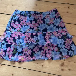 Jättesöt kjol från Lola Skye med rosa och blåa blommor. Storlek 38 men ganska kort. Den har även en dragkedja som inte syns, så det blir lättare att ta på. Aldrig använd! 