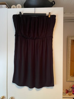 Klänning - En axelbandslös svart klänning. Storlek: XL. 