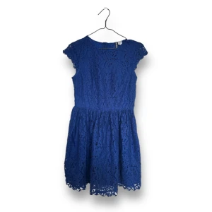 Klänning i spets - Klänning i blå spets. Fint skick! Knappar baktill samt dragkedja i sidan. 