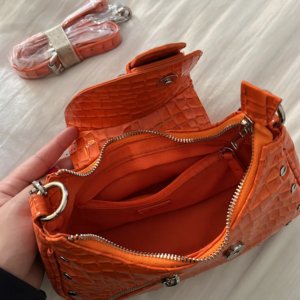 Lägger upp igen!!! Superfin orange väska från nakd, använd 1 gång, tillkommer ett längre band med som aldrig packats upp.  Kommer ej till användning. Nypris: 499kr . Väskor.