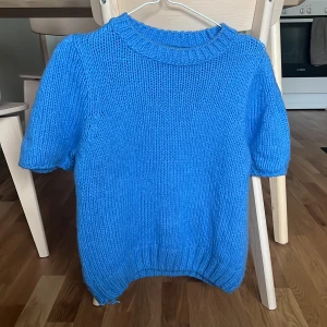 Blå stickad, kortärmad tröja - Klarblå, kortärmad tröja i storlek 38 men passar mig som brukar ha 36 i stickade tröjor. 