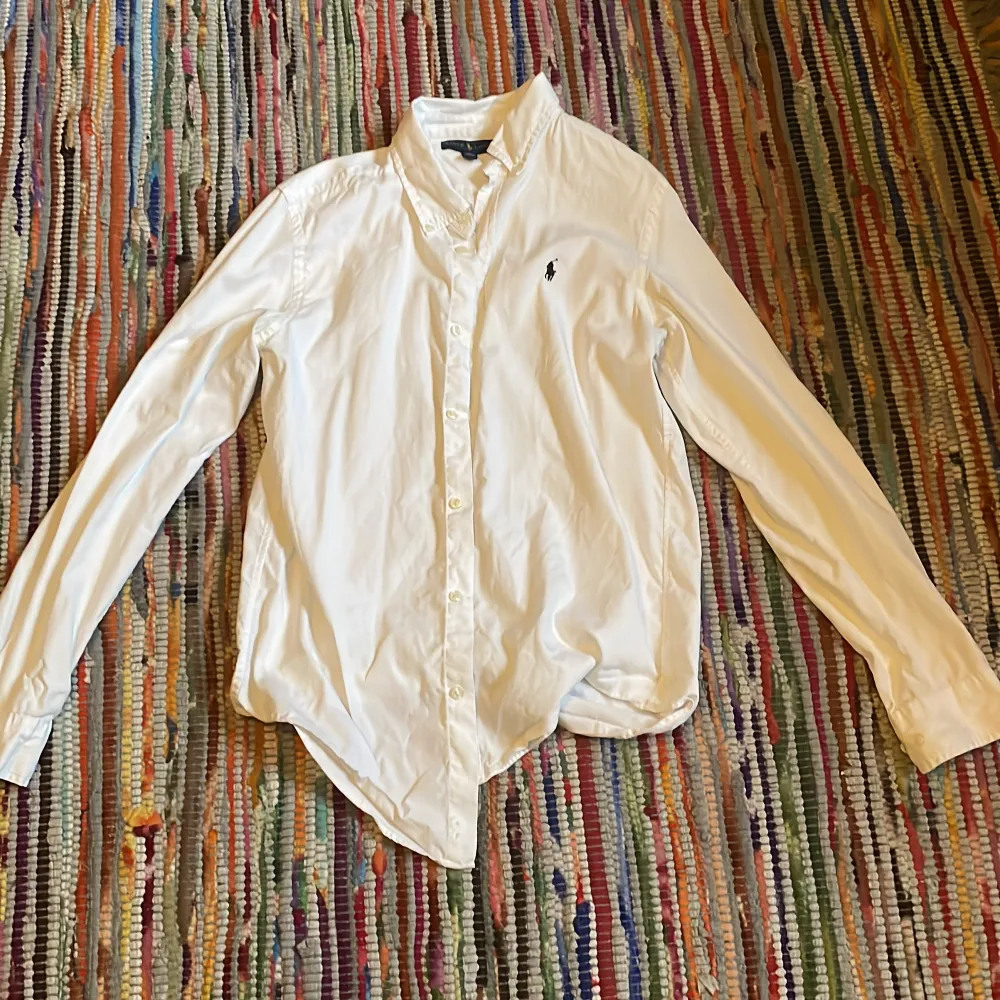 Säljer denna sjukt snygga vita skjortan från Ralph lauren som tyvärr blivit för liten för mig. Kan användas vid alla tillfällen! Super bra skick och säljs för ett grymt pris . Skjortor.