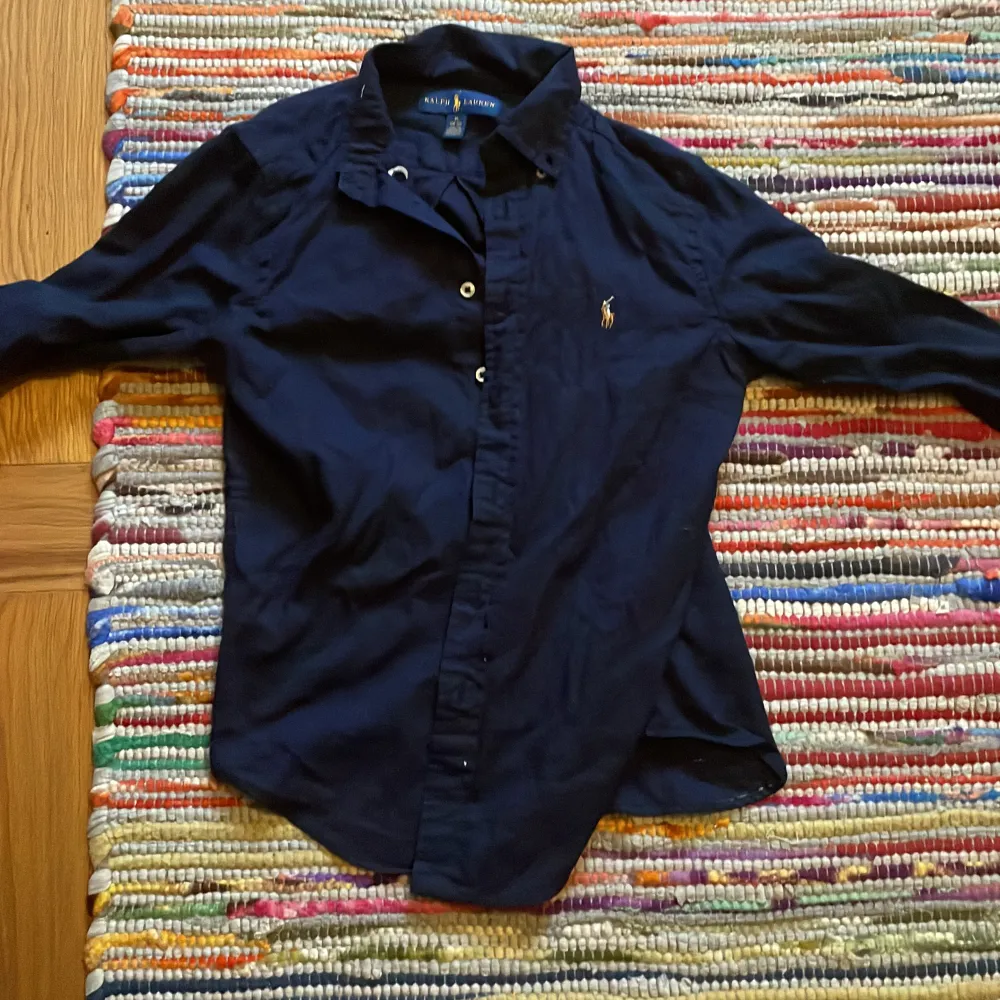 Marinblå skjorta ralph lauren Super bra skick och kan användas vid alla tillfällen som dessutom är i ett sjukt bra pris! . Skjortor.
