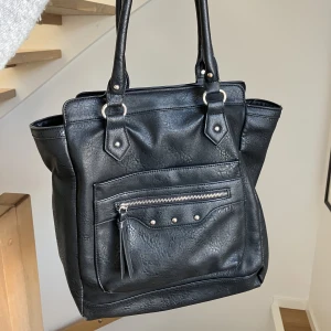 Svart stor axelväska  - Säljer den här stora, svarta axelväska med silver detaljer. Säljer då jag inte använder den längre. Den får plats med mycket!💕