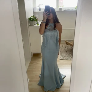 Perfekta balklänningen  - Säljer en balklänning som endast använts en gång! Superfin och unik och har perfekta passformen. Går att ha både med och utan Frans/dekor detaljen som man ser på bild 2. Den trär man separat över klänningen. Storlek 38! 