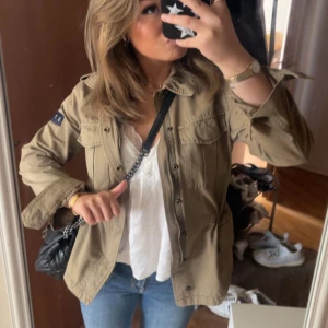 Grön safarijacka - Säljer min älskade safarijacka. Använt ett par gånger, men fortfarande i bra skick! Justerbar vid midjan och köpt för 1259 kr från boozlet :) pris går att diskuteras!