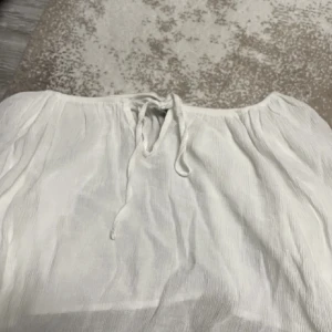 Mesh topp - En vit mesh topp med utsvängda armar. Den är väldigt croppad och man kan styra själv hur den ska sitta vid axlarna. Modellen på ärmarna är lite kort. Aldrig använt! 