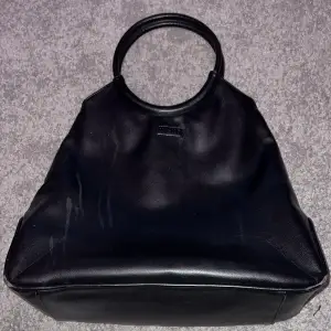 En svart NAKD handväska med mycket utrymme och väldigt minimalistisk. För dig som inte vill att väskan ska ta all uppmärksamhet helt enkelt. Det finns några fläckar på den som man kan se i bilderna. Annars jätte schysst utan några fel. Frågor? Skriv gärna